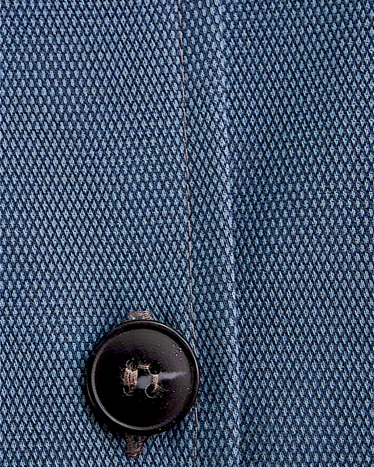 Close-up of Lefke Legacy steel blue cotton jubba fabric showing fine weave texture and a dark button detail.