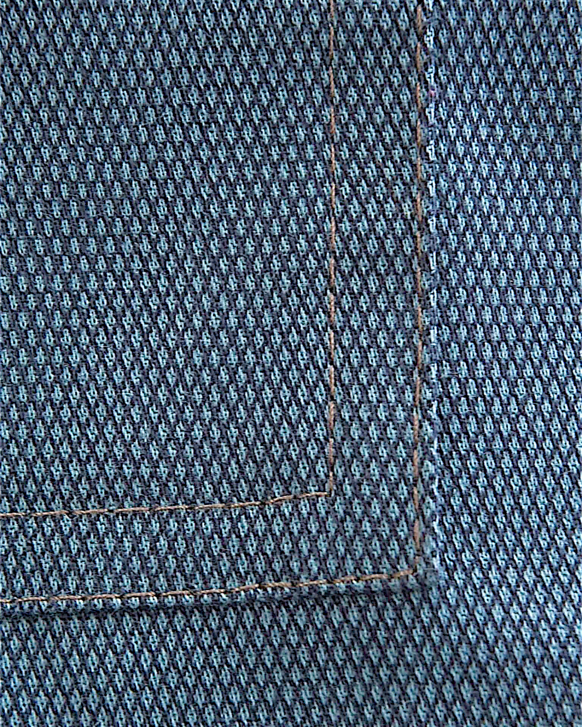 Close-up of Lefke Legacy steel blue cotton jubba fabric showing the fine weave and detailed stitching on the pocket.