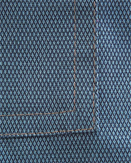 Close-up of Lefke Legacy steel blue cotton jubba fabric showing the fine weave and detailed stitching on the pocket.